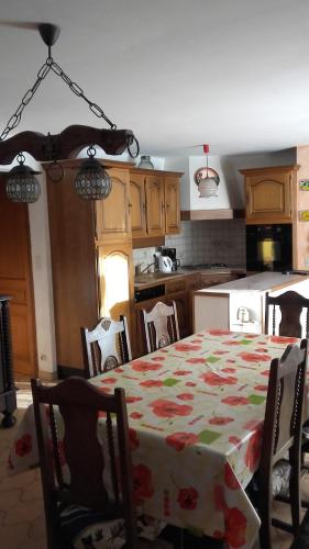 une cuisine avec une table et un tissu de table fleuri dans l'établissement La Grande Lauze, à Champcella