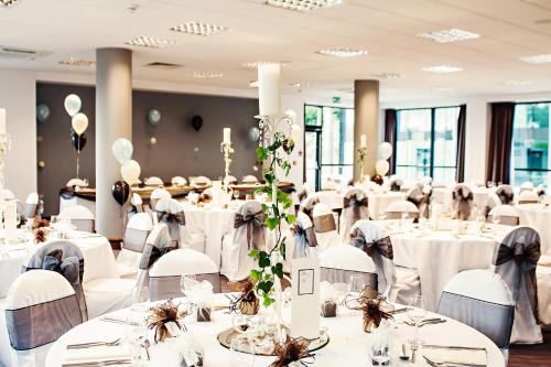 a banquet hall with white tables and chairs at Leonardo Hotel Newcastle Quayside in Newcastle upon Tyne