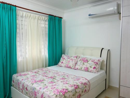 a small bedroom with a bed with pink flowers at Homestay Farah Wangsa Maju KL in Kuala Lumpur