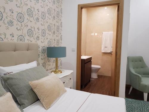 a bedroom with a bed and a bathroom at 22 Oporto Guesthouse in Porto