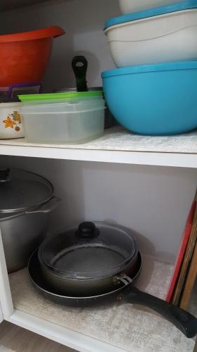 a frying pan in the middle of a shelf with bowls at Apartment in the Karakol heart in Karakol