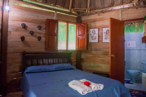 1 dormitorio con 1 cama con toallas en Posadas Ecoturisticas Seineken, en El Zaino