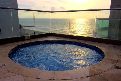 bañera de hidromasaje en el balcón de un edificio con vistas al océano en De Lujo-Palmetto Eliptic Playa Panoramico, en Cartagena de Indias