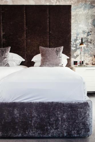 a bedroom with a large white bed with a black headboard at Malmaison Edinburgh in Edinburgh