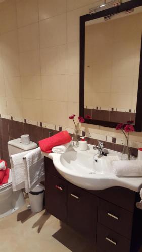 a bathroom with a sink and a toilet and a mirror at Residencial Cotillo Playa in Cotillo