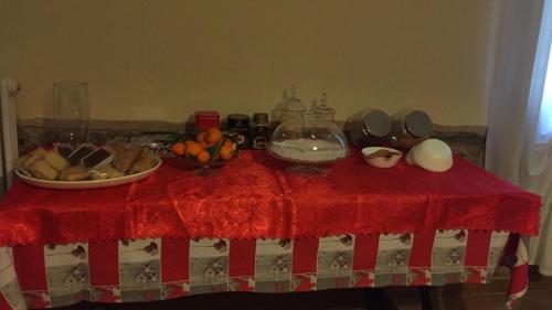 a table with a bowl of fruit on a red table cloth at B&B Happiness in the Country in Brescello