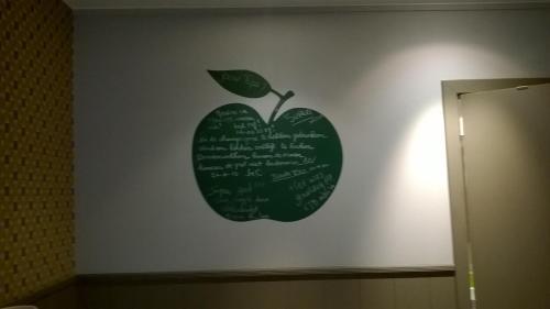 a green apple on a wall with writing on it at B&B De Zoete Kers in Wakken
