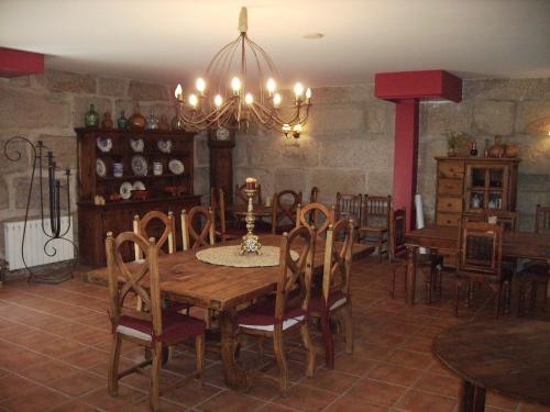 a dining room with a wooden table and chairs at Os Areeiros Turismo Rural & Bodega in Santa Cristina de Cobres