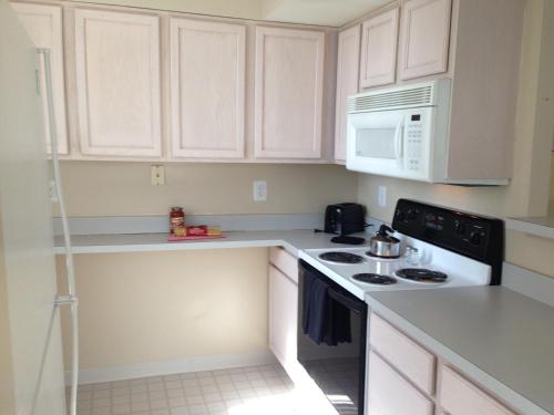 a kitchen with white cabinets and a stove and microwave at National at Ballston Metro in Arlington