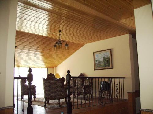 a living room with chairs and a wooden ceiling at Os Areeiros Turismo Rural & Bodega in Santa Cristina de Cobres