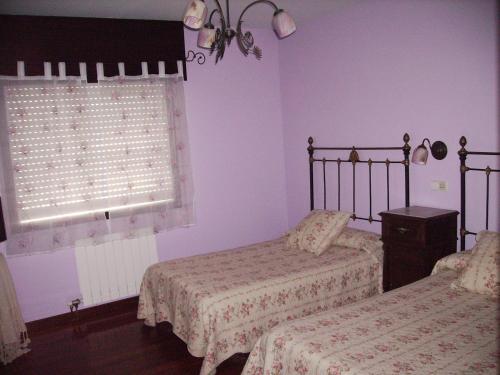 a bedroom with two beds and a window at Os Areeiros Turismo Rural & Bodega in Santa Cristina de Cobres