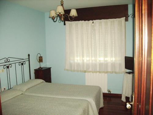 a bedroom with a bed and a window at Os Areeiros Turismo Rural & Bodega in Santa Cristina de Cobres