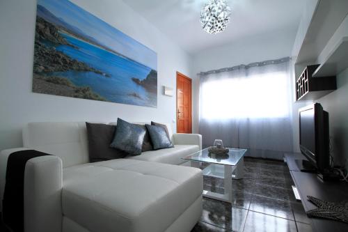 a living room with a white couch and a tv at Cotillo Sea in Cotillo