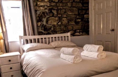 a bedroom with a bed with towels on it at The George & Dragon Felton in Felton