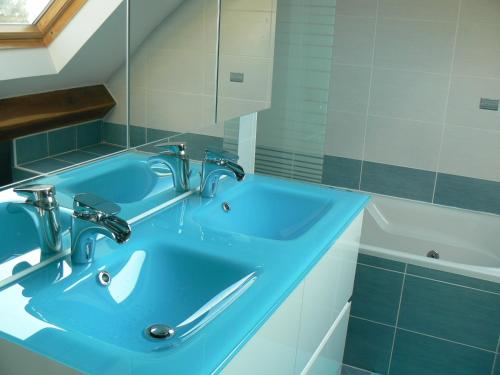 a bathroom with a blue sink and a tub at Le Manoir des Chapelles in Venoy