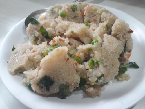a white plate of food with rice and peas at golden dormitory in Mumbai