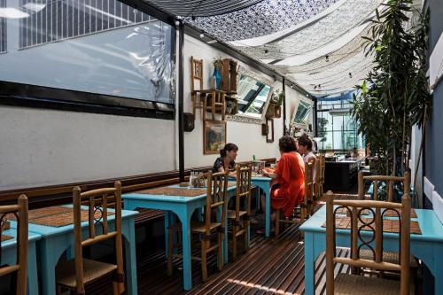 a group of people sitting at tables in a restaurant at Casa Tuxi in Rio de Janeiro