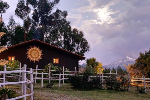 a barn with a sunflower on the front of it at The Lazy Dog Inn a Mountain Lodge in Huaraz