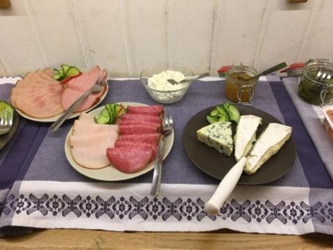 una mesa con dos platos de carne y queso en Hotell Hässlö en Västerås
