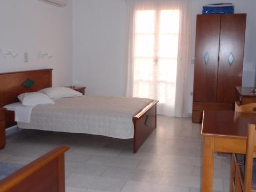 a bedroom with a bed and a large window at Galanos Studios in Naxos Chora