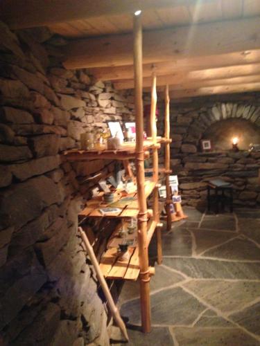 a room with a stone wall and a wooden shelf at Ivaregga Vinterstua in Tolga