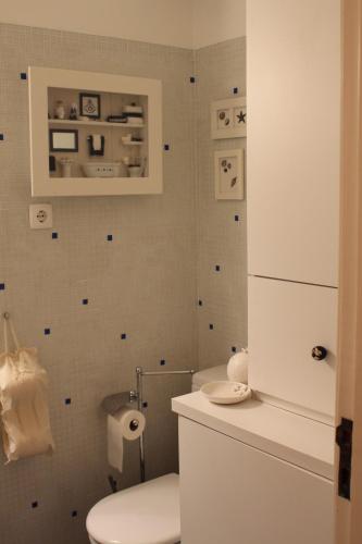 a bathroom with a white toilet and a white refrigerator at Rose's House in Costa da Caparica