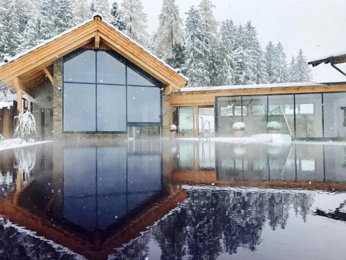 a house in the snow with a pool at Hotel Annelies in Ramsau am Dachstein