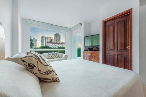 a bedroom with a large bed and a large window at Coral Reef Hotel in Cartagena de Indias