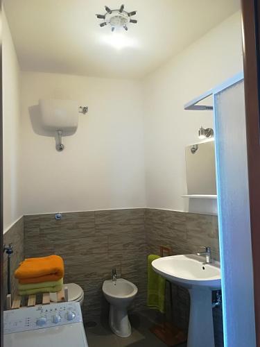 a bathroom with two sinks and a toilet at Castello Apartment in Bacoli