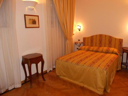 a hotel room with a bed and a chair at Al Teatro in Livorno