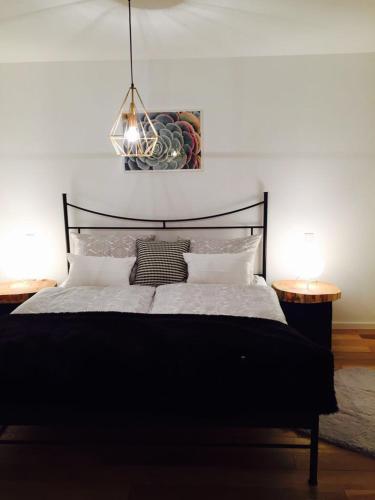 a bedroom with a black bed with two tables at Ferienhaus mit Sonnendeck in Sankt Wendel