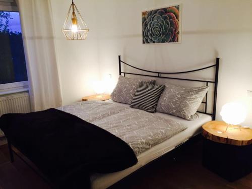 um quarto com uma cama preta e 2 candeeiros em Ferienhaus mit Sonnendeck em Sankt Wendel