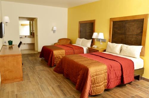 a hotel room with two beds and a television at Hotel Villa del Sol in Ciudad Juárez