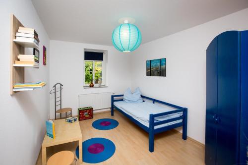 エアフルトにあるFerienhaus-Pressler-Erfurtの青いベッドと窓付きの小さなベッドルームが備わります。