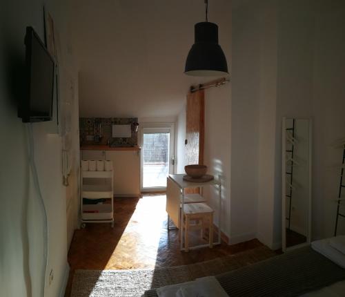 um quarto com uma cozinha com uma mesa e uma janela em Cosy Attic City center em Lisboa
