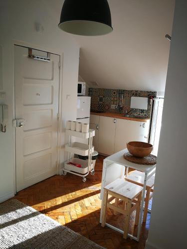 um quarto com uma cozinha com uma mesa e um frigorífico em Cosy Attic City center em Lisboa