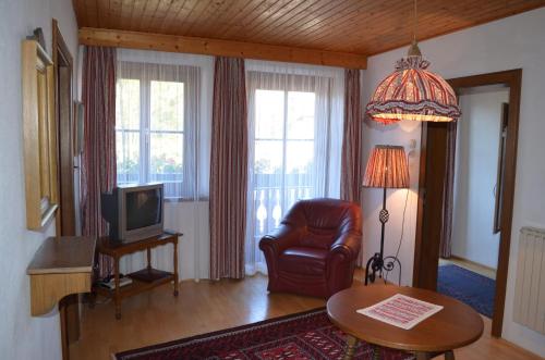 a living room with a chair and a television at "Kaiser Karl" *** Ferienwohnungen in Grossgmain