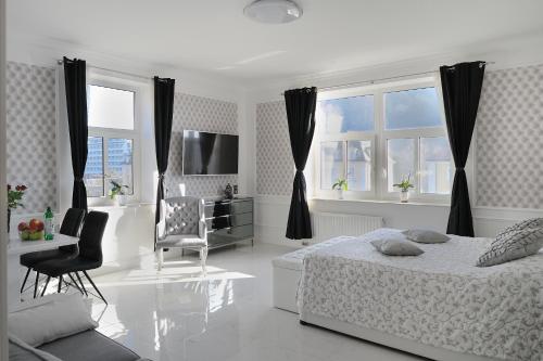 a white bedroom with a bed and a chair at Apartment Sloapart in Rogaška Slatina