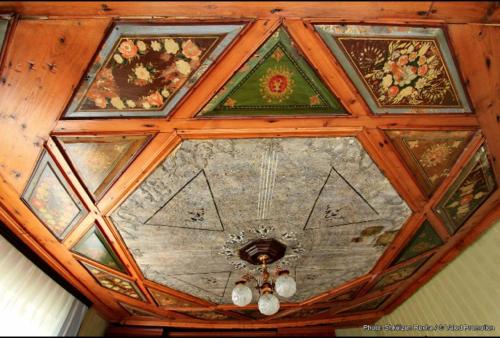 a ceiling with paintings on it with a chandelier at Bujtina Zhaveli in Gjakove