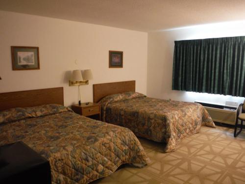 a hotel room with two beds and a window at Caravan Motel in Cannon Falls