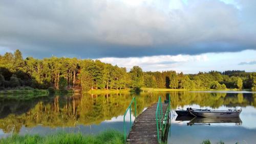 a boat is docked next to a dock on a lake at Domaine du Balbuzard in Condat-en-Combraille