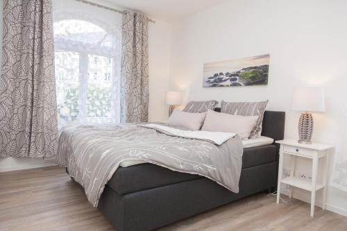 1 dormitorio con 1 cama grande y ventana en Stadtvilla mit Hafenpanorama, en Flensburg