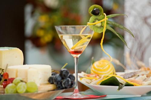 a martini glass with a bird on it next to a plate of food at Card International Hotel in Rimini