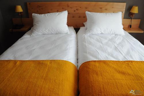 two beds sitting next to each other in a room at Hostal Buena Tierra in Pucón