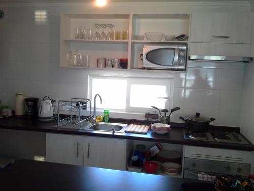 a small kitchen with a sink and a microwave at Lomas Papudo 4 in Papudo