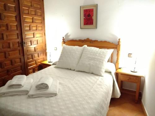 カソルラにあるApartamentos Asador De La Plaza Viejaのベッドルーム1室(白いベッド1台、タオル2枚付)