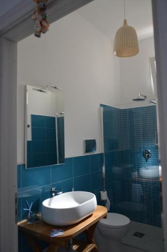 a bathroom with a sink and a toilet and a mirror at B&B Albatros in Castelluzzo