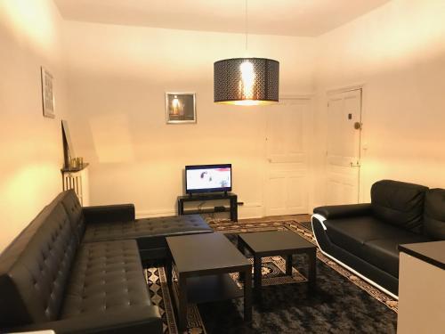 sala de estar con sofá y TV en Luxury Suite Lilas 1 en Dijon