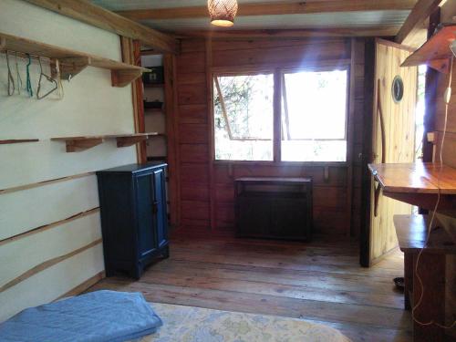a room with a wooden floor and a window at L'Auberge Polynésienne in Tevaitoa