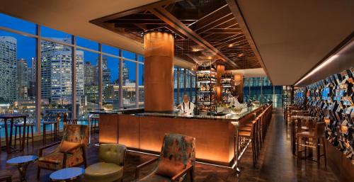 a bar in a restaurant with a view of a city at Sofitel Sydney Darling Harbour in Sydney